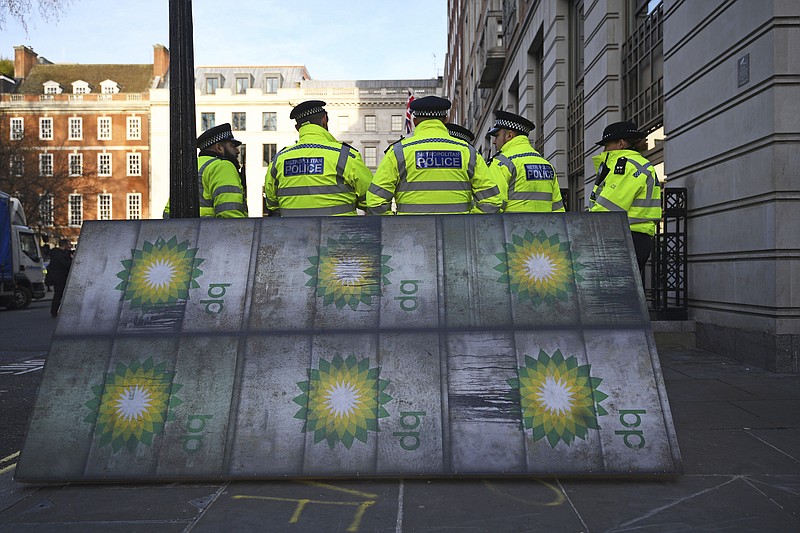 Police officers stand near activists outside BP's headquarters to mark the first day of the oil company's new chief executive Bernard Looney, at St James' Square in London, Wednesday Feb. 5, 2020. Around 100 environmental activists mounted the peaceful protest in central London as Bernard Looney prepared to take up his new role. (Victoria Jones/PA via AP)