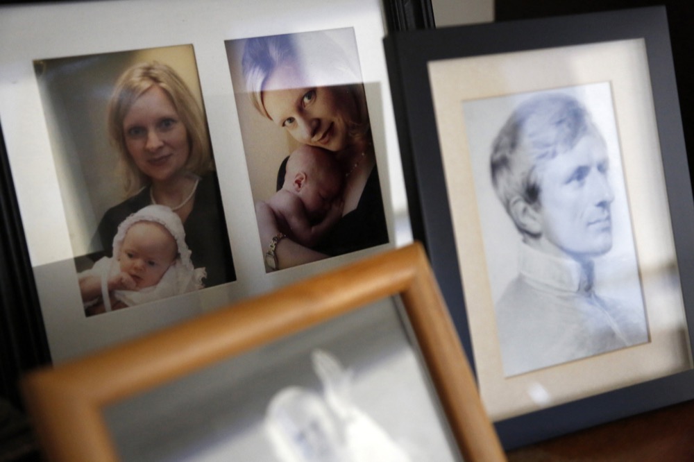 In this Feb. 7, 2020, photo, pictures of The Rev. Joshua Whitfield’s wife, Alli, and eldest daughter Maggie sit next to framed photographs of Saint John Paul II and Saint John Henry Newman, all lining the top of a bookshelf in his office at St. Rita Catholic Community in north Dallas. Whitfield came to the Catholic church as a former Episcopalian pastor, a husband and soon-to-be dad. (AP Photo/Jessie Wardarski)