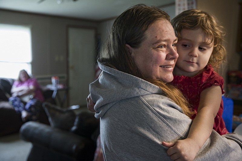 Staff photo by Troy Stolt / Regina Laughlin holds up her granddaughter Topanga, 4, in her home on Thursday, Feb. 13, 2020 in Summerville, Georgia. On January 31st, Summerville residents were advised not to consume their tap water after cancer causing chemicals were discovered during a quality inspection done by the Environmental Protection District of Georgia. Regina, who is employed by the Mohawk Industries mill, expressed concerns of the logistics of picking up fresh water for her family, as she often works during pick up hours. As the summer approaches, she's concerned they won't be able to get enough clean water to fill her family's needs.