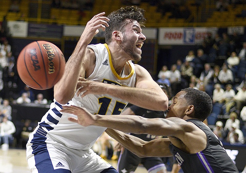 Staff photo by Robin Rudd / Furman's Jaylon Pugh, right, knocks the ball away from UTC's Ramon Vila during a SoCon game on Jan. 8 at McKenzie Arena.