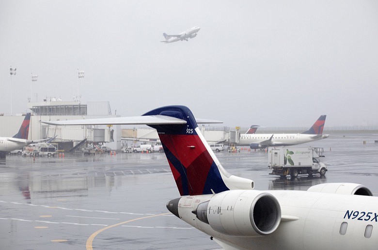 In this Oct. 29, 2019, file photo Delta planes are parked at the new $3.9 billion Terminal C at LaGuardia Airport in New York. Delta Air Lines said Friday, Feb. 14, 2020, that it will invest $1 billion over the next 10 years in measures designed to offset climate-warming carbon emissions from its planes. (AP Photo/Mark Lennihan, File)