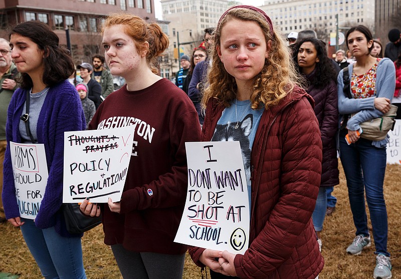 Rosa Anderson, left, Virginia Alsoerooks, center, and Ellie Swann react as the names of 17 victims of last year's school shooting in Parkland, Fla., are read during a rally against gun violence organized by Chattanooga Students Leading Changed in Miller Park on Saturday, Feb. 16, 2019, in Chattanooga, Tenn. Students, their families and supporters rallied to denounce gun violence just over one year after the Parkland shooting.