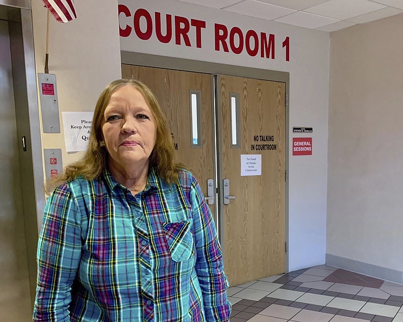 In this Jan. 23, 2020 photo, Susie Duvall, of Jamestown, Tenn., poses outside a courtroom in the Putnam County Courthouse in Cookeville, Tenn. Duvall went to Cookeville Regional Medical Center in September 2018 with confused speech and an aching arm. She stayed a full week and left with a bill that even after insurance, left her to pay more than $9,000. Her arrangement with the court will take more than a decade to pay off. (Blake Farmer/WPLN via AP)

