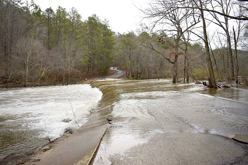 Staff photo by Ben Benton / Rain-swollen South Sauty Creek on Feb. 13, 2020, still rushes over the crossing in Buck's Pocket State Park on the DeKalb-Jackson county line in Alabama where a person and vehicle went missing Feb. 5, 2020, amid high flood waters. On Sunday, the body of 82-year-old Scottsboro resident Raymond Edwards was recovered from the creek.
