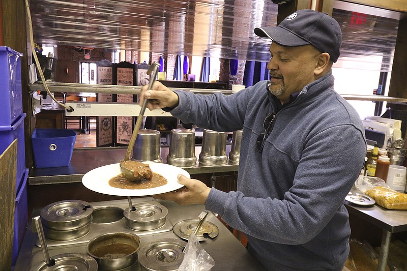 Staff File Photo / Michael Adams, executive chef and owner of Blue Orleans Restaurant on Chattanooga's Southside, dishes up his signature Creole Red Beans and Rice in this 2015 file photo.