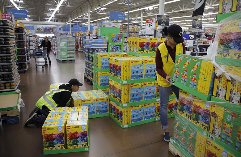 In this Nov. 27, 2019, file photo Jayln Martin, right, and Dan Villegas stock items in preparation for a holiday sale at a Walmart Supercenter in Las Vegas. On Friday, Jan. 31, 2020, the Labor Department reports on wages and benefits for U.S. workers during the Oct.-Dec. quarter. (AP Photo/John Locher, File)