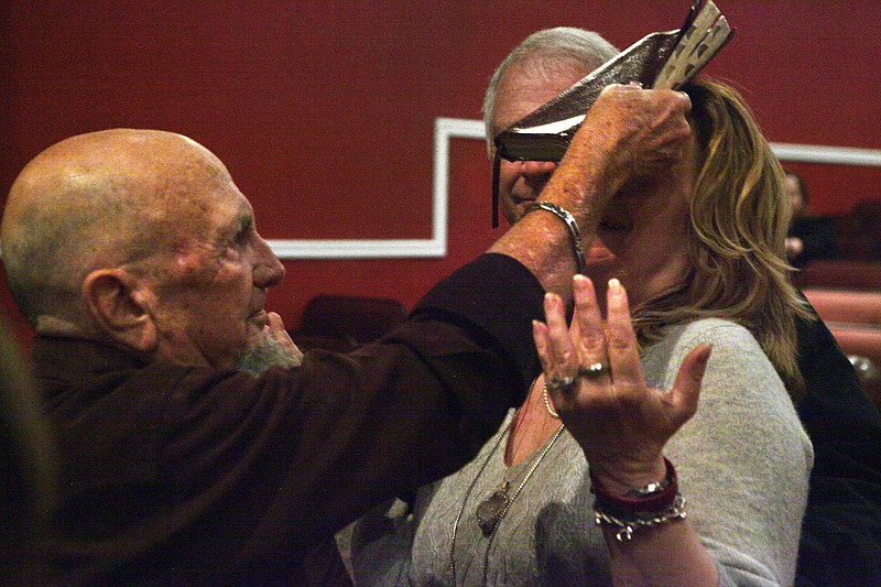 Staff photo by Wyatt Massey / Jerry Pearce places his Bible on the heads of guests at the Wink Theatre in Dalton, Georgia on Nov. 19, 2019.