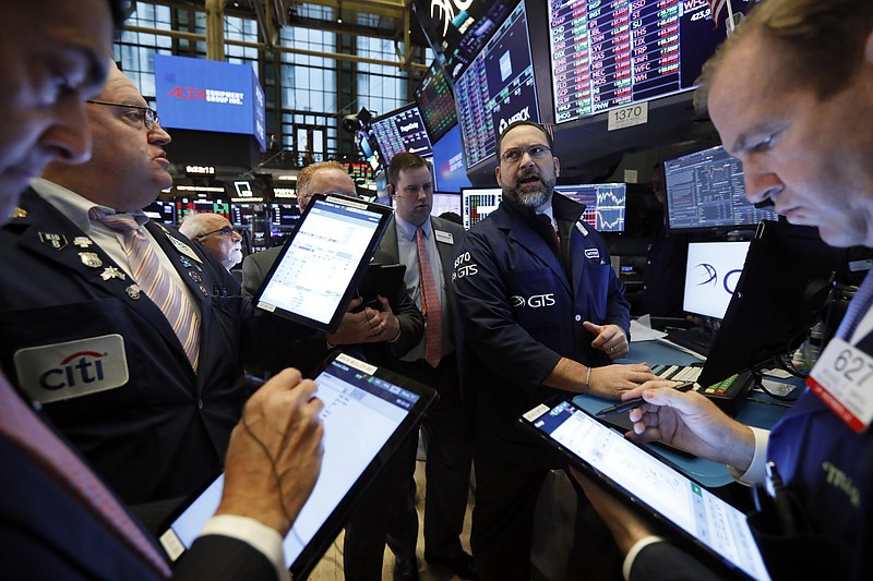Traders gather at the post of Specialist Anthony Matesic, background center, on the floor of the New York Stock Exchange, Tuesday, Feb. 18, 2020. Stocks are opening lower on Wall Street after Apple said it would fail to meet its revenue forecast for the current quarter due to the impact of the virus outbreak in China. (AP Photo/Richard Drew)