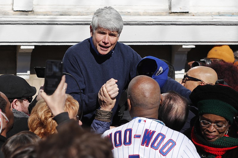 Photo by Charles Rex Arbogast of The Associated Press / Former Illinois Gov. Rod Blagojevich acknowledges Chicago Cubs' fam Ronnie Woo Woo after a news conference outside his home on Wednesday, Feb. 19, 2020, in Chicago. On Tuesday, President Donald Trump commuted Blagojevich's 14-year prison sentence for political corruption.