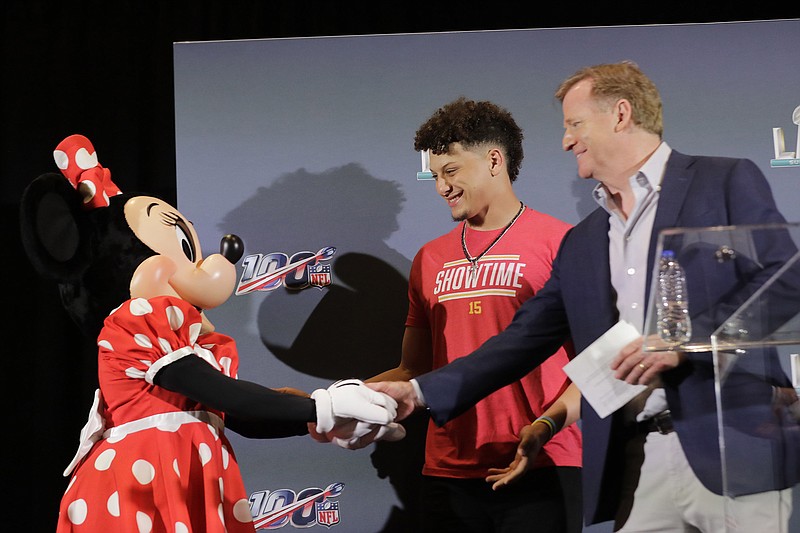 AP photo by Brynn Anderson / NFL commissioner Roger Goodell, right, and Kansas City Chiefs quarterback Patrick Mahomes greet Minnie Mouse during a news conference in Miami on Feb. 3, 2020, the day after the Chiefs closed the 2019 season by beating the San Francisco 49ers in Super Bowl LIV. With each passing day in the COVID-19 crisis, the likelihood of the pandemic having some impact on the next NFL season increases.