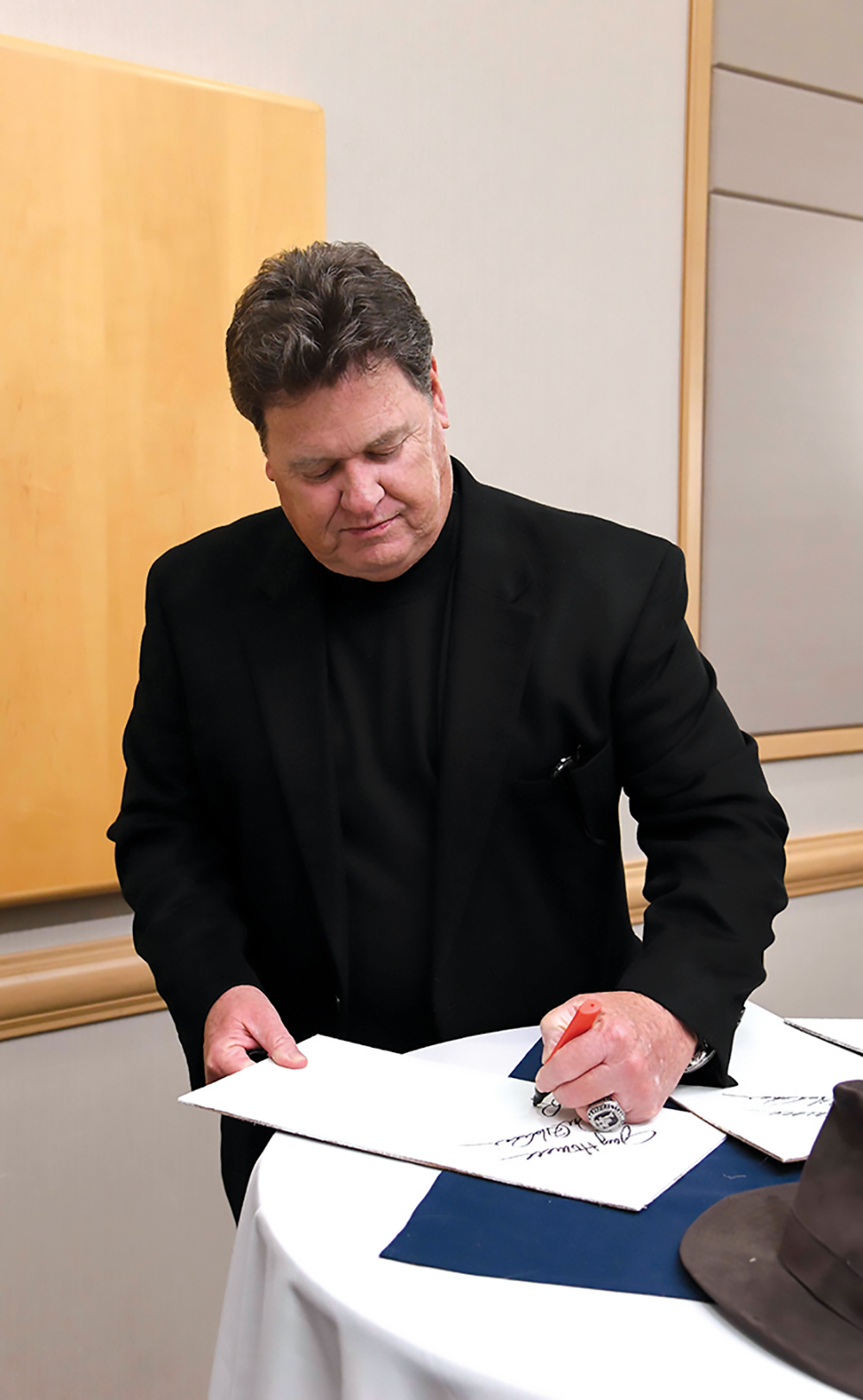 Rick Honeycutt signs atuographs before the dinner started./ Photo by Mark Gilliland