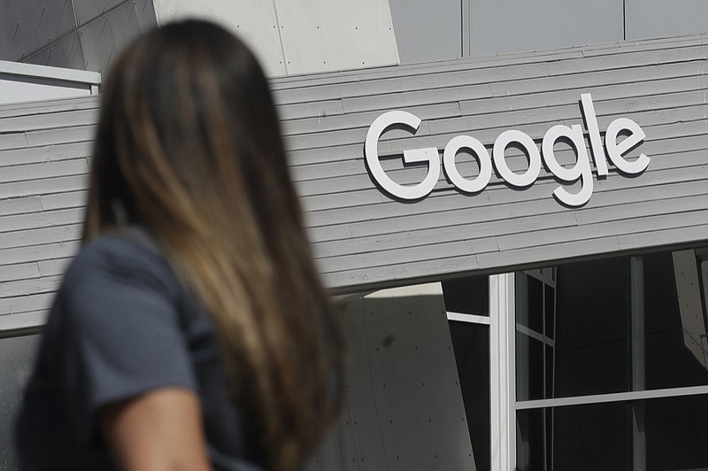 FILE - In this Sept. 24, 2019, file photo, a woman walks below a Google sign on the campus in Mountain View, Calif. (AP Photo/Jeff Chiu, File)


