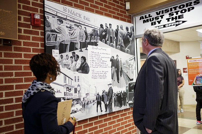Staff File Photo / Howard School Principal LeAndrea Ware, left, shows Geoff Ramsey a mural depicting the 1960 lunch-counter sit-ins by Howard School students.
