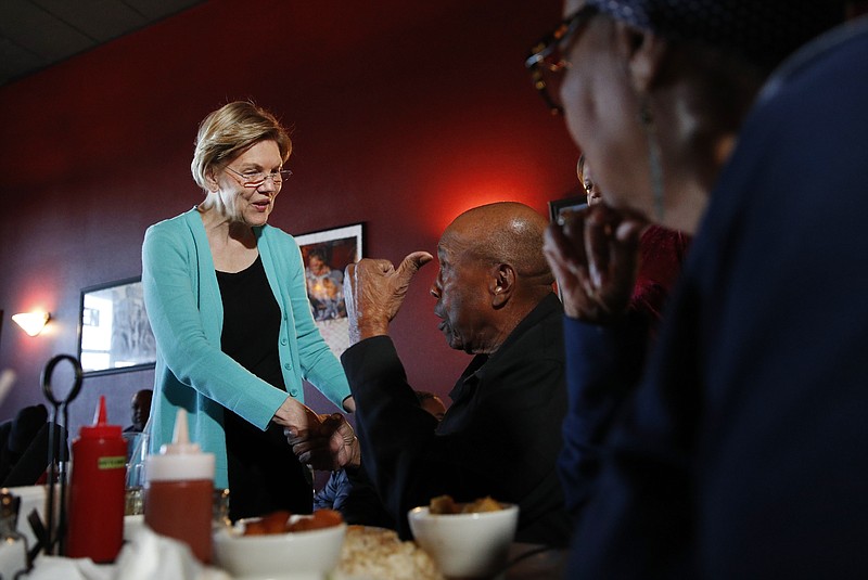 Democratic presidential candidate Sen. Elizabeth Warren, D-Mass., speaks with Bill Mamgum, center, and Shirley Mamgum at EllaEm's Soul Food, Thursday, Feb. 20, 2020, in North Las Vegas, Nev. (AP Photo/John Locher)