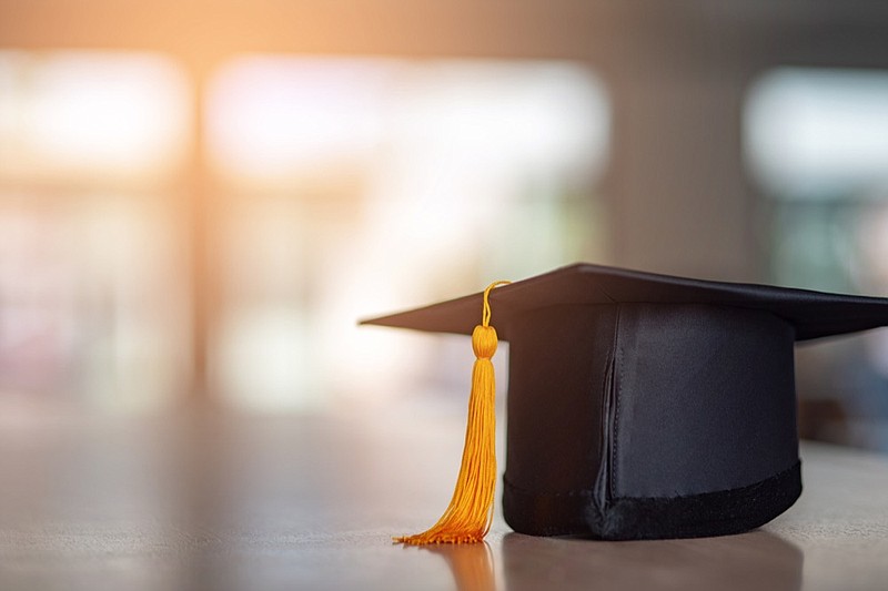 Black hat and yellow tassel of graduates placed on a wooden table grad tile graduation college school education tile graduation cap grad hat / Getty Images
