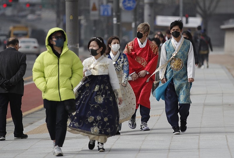 Visitors wearing face masks walk near the Gwanghwamun, the main gate of the 14th-century Gyeongbok Palace, and one of South Korea's well-known landmarks, in Seoul, South Korea, Saturday, Feb. 22, 2020. South Korea's Vice Health Minister Kim Gang-lip says the outbreak has entered a serious new phase but expressed cautious optimism that it can be contained to the region surrounding Daegu, where the first case was reported on Tuesday. (AP Photo/Lee Jin-man)


