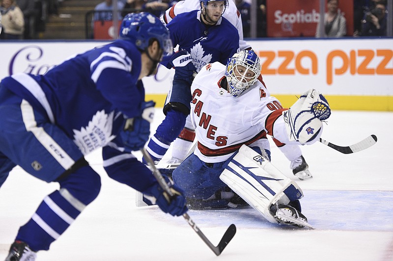 The Canadian Press photo by Frank Gunn via The Associated Press / Toronto Maple Leafs left wing Pierre Engvall, left, scores his team's third goal of the game against Carolina Hurricanes emergency goalie David Ayres during the second period Saturday night in Toronto.