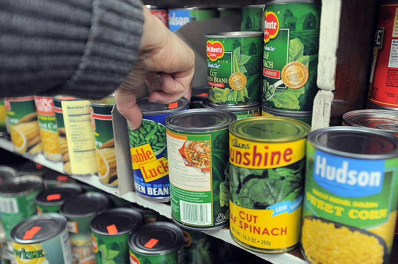 Cathy Demeroto, director of Maryland Hunger Associates, grabs a can of vegetables at Lee's Food Market in the Sandtown-Winchester community in Baltimore, January 28, 2011. The shopping experiment, conducted at an inner-city neighborhood market, uses $30 to see what food stamp items can be purchased. (Karl Merton Ferron/Baltimore Sun/MCT)