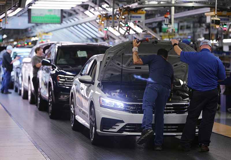 Volkswagen employees check items under the hood of a vehicle before it is driven off the assembly line at the Volkswagen Plant Thursday, Aug. 31, 2017, in Chattanooga, Tenn. 