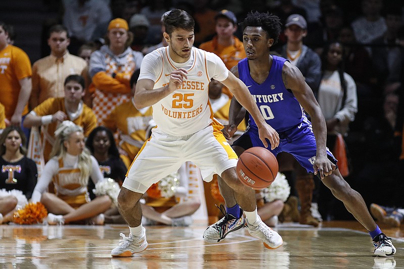Tennessee point guard Santiago Vescovi (25) loses control of the ball as he's defended by Kentucky's Ashton Hagans during their Feb. 8 game in Knoxville. / AP Photo/Wade Payne