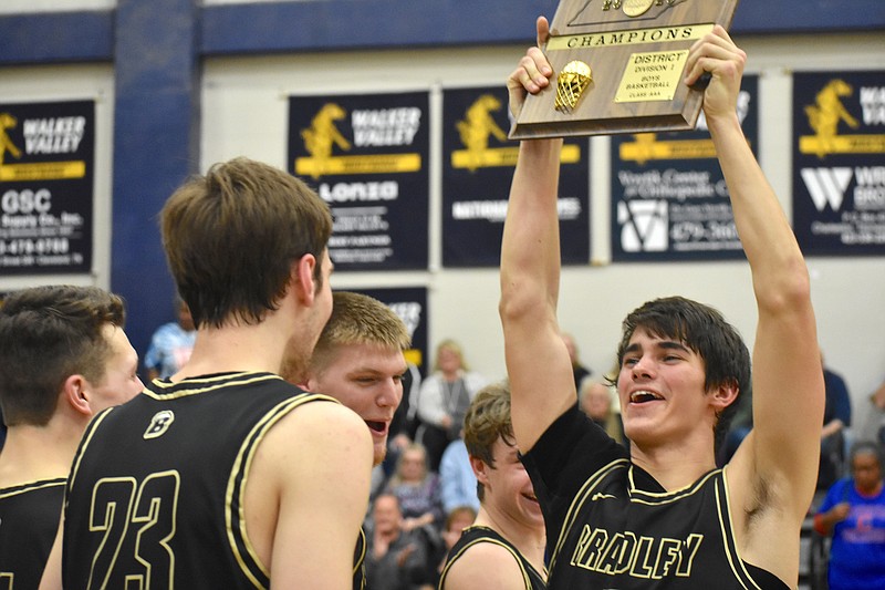 Bradley Central senior Saylor Clark lifts the District 5-AAA championship plaque over his head after a win over previously undefeated Cleveland at Walker Valley High School on Tuesday night./ Staff photo by Patrick MacCoon