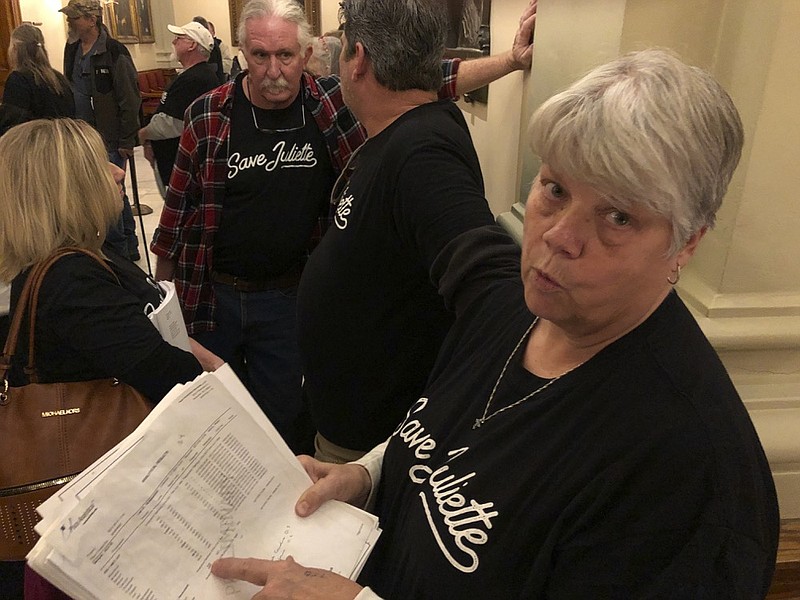 Gloria Hammond, a resident of Juliette, Georgia, shows off water tests that display contaminants in her homes' well at the Georgia capitol on Monday, February 24, 2020. Georgia Power Co., which operates a nearby coal-fired power plant, says its monitoring wells show no contamination from a coal ash pond. The Senate passed Senate Bill 123 on Monday by a vote of 52-2, sending it to the House for more work. The measure would raise the fee for dumping coal ash from $1 a ton to $2.50 a ton, equaling what it costs to dispose of other kinds of garbage at Georgia landfills. (Jeff Amy/Associated Press)


