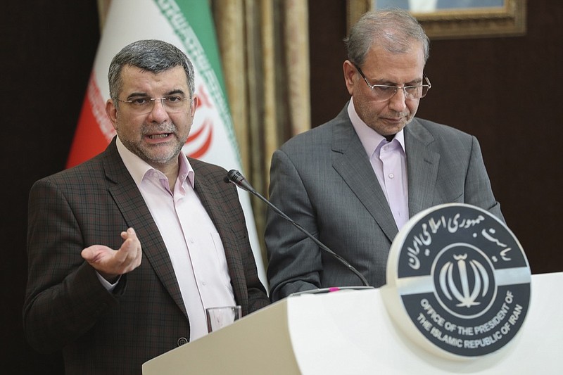 In this Monday Feb. 24, 2020 photo, released by the official website of the office of the Iranian Presidency, the head of Iran's counter-coronavirus task force, Iraj Harirchi, left, speaks at a press briefing with government spokesman Ali Rabiei, in Tehran, Iran. Harirchi, has tested positive for the virus himself, authorities announced Tuesday, amid concerns the outbreak may be far wider than officially acknowledged. The announcement regarding Harirchi came after the news conference seeking to minimize the danger posed by the outbreak. (Iranian Presidency Office via AP)