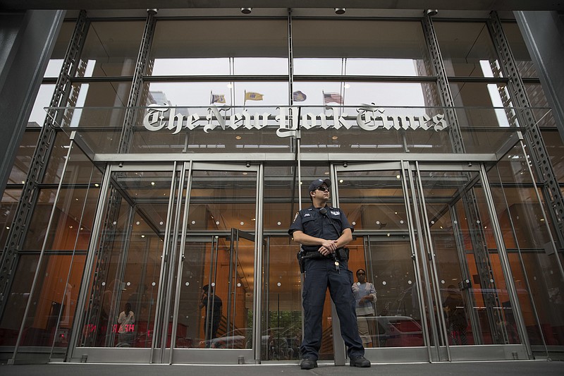 FILE - In this June 28, 2018, file photo, a police officer stands guard outside The New York Times building in New York. The campaign to reelect President Donald Trump sued The New York Times for defamation Wednesday, Feb. 26, 2020, saying it was responsible for an essay by a former executive editor for the newspaper that claimed the campaign made a deal with Russian officials to defeat Hillary Clinton in 2016. (AP Photo/Mary Altaffer, File)