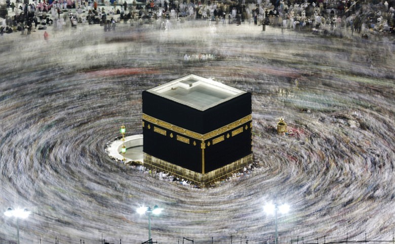 In this Aug. 13, 2019, file photo taken with a slow shutter speed, Muslim pilgrims circumambulate the Kaaba, the cubic building at the Grand Mosque, during the hajj pilgrimage in the Muslim holy city of Mecca, Saudi Arabia. Saudi Arabia on Thursday, Feb. 27, 2020, halted travel to the holiest sites in Islam over fears of the global outbreak of the new coronavirus just months ahead of the annual hajj pilgrimage, a move coming as the Mideast has over 220 confirmed cases of the illness. (AP Photo/Amr Nabil, File)