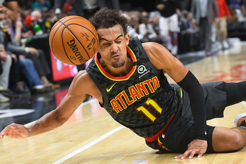 AP photo by John Amis /  Atlanta Hawks point guard Trae Young tries to keep the basketball from going out of bounds during Wednesday night's home game against the Orlando Magic.