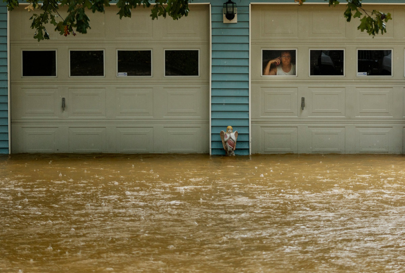 Staff photo by Doug Strickland / A woman looks at rising floodwaters from the garage of a home on Dallas Hollow Road after heavy rainfall on Wednesday, Sept. 26, 2018, in Soddy-Daisy, Tenn. Heavy rains throughout the week caused flooding and closed schools across the region.