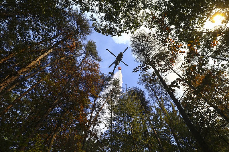 Staff Photo by Dan Henry / The Chattanooga Times Free Press- 10/12/16. One of two Tennessee Air National Guard helicopters dumps water from above while working with the Tennessee Division of Forestry and other emergency personnel to continue to battle a wildfire burning atop Signal Mountain which started this past weekend.