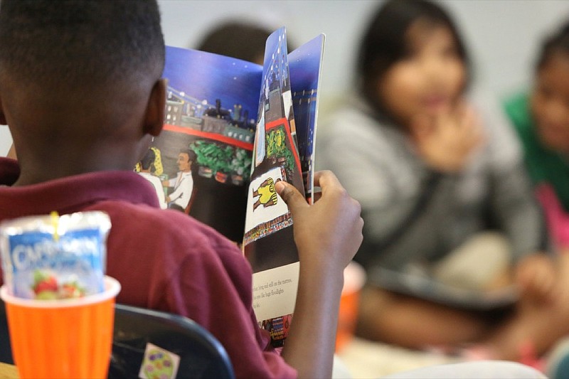 Staff photo by Erin O. Smith / De'Arion Johnson, 8, reads from his book during an after school book club hosted by Catherine Casselman Thursday, April 18, 2019 in Chattanooga, Tennessee. Casselman is a second grade teacher at East Side Elementary School.