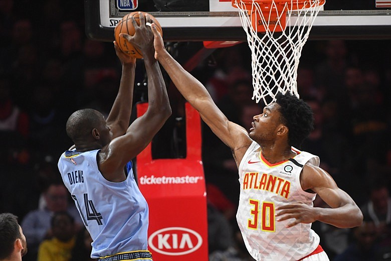 Atlanta Hawks center Damian Jones (30) defends against a shot by Memphis Grizzlies center Gorgui Dieng during the first half of an NBA basketball game Monday, March 2, 2020, in Atlanta. (AP Photo/John Amis)