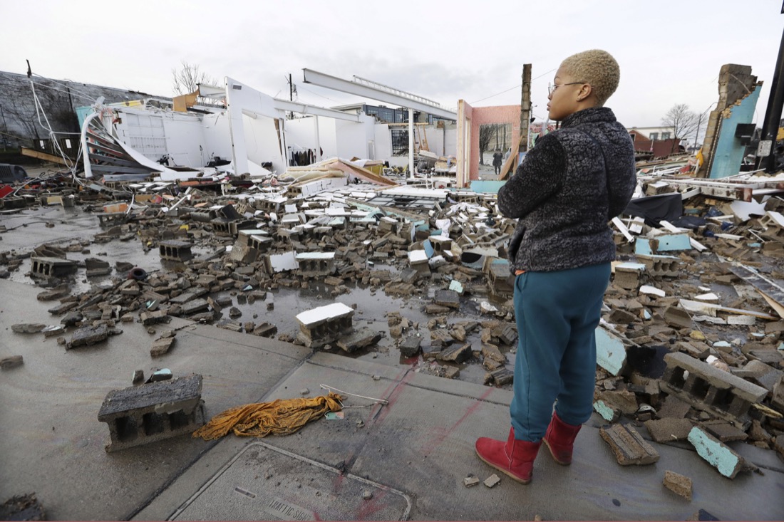 Faith Patton looks over buildings destroyed by storms Tuesday, March 3, 2020, in Nashville, Tenn. At least two tornadoes touched down early Tuesday in central Tennessee, including one that ripped across areas near downtown Nashville and caused multiple buildings to collapse. Patton lives near the damaged area but her home was intact. (AP Photo/Mark Humphrey)