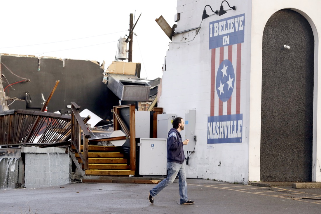 A man walks by The Basement East, a live music venue destroyed by storms Tuesday, March 3, 2020, in Nashville, Tenn. At least two tornadoes touched down early Tuesday in central Tennessee, including one that ripped across areas near downtown Nashville and caused multiple buildings to collapse. (AP Photo/Mark Humphrey)
