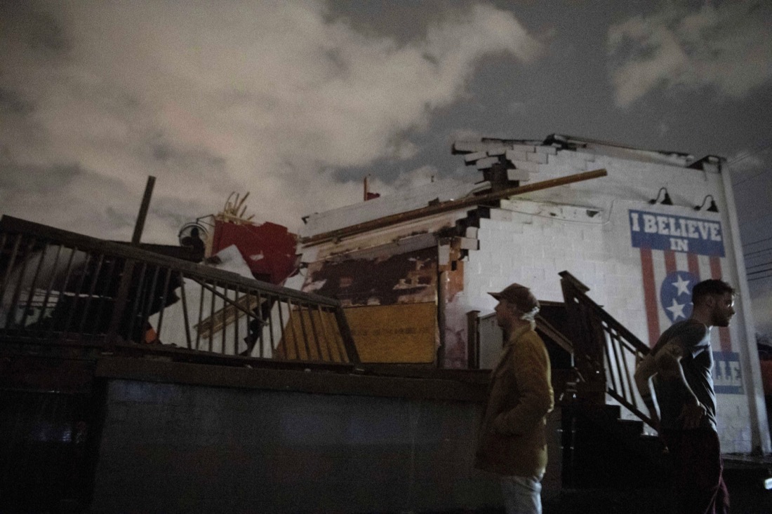 People stand outside the Basement East music venue in East Nashville after it was destroyed by a tornado on Tuesday, March 3, 2020. (Courtney Pedroza/The Tennessean via AP)