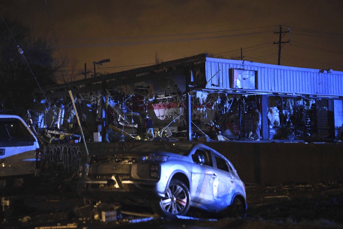 People survey the damage to a building in East Nashville after a tornado hit the city in the early morning hours of Tuesday, March 3, 2020. (Courtney Pedroza/The Tennessean via AP)