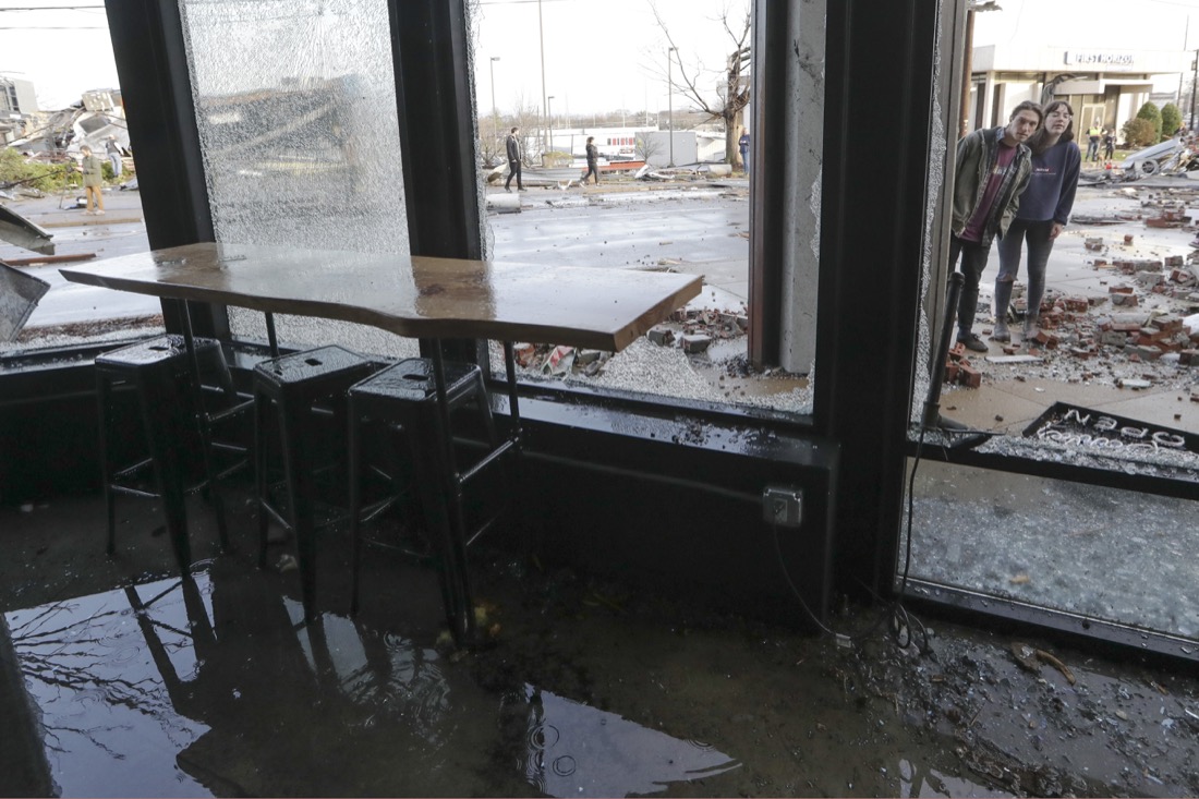 People look in a restaurant damaged by storms Tuesday, March 3, 2020, in Nashville, Tenn. Tornadoes ripped across Tennessee early Tuesday, shredding buildings and killing multiple people. (AP Photo/Mark Humphrey)