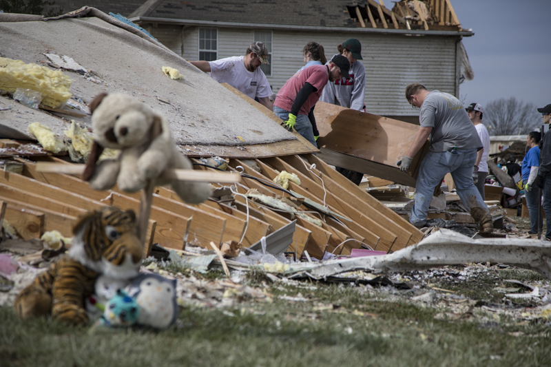 Staff photo by Troy Stolt / Volunteers work to clear debris from the Phillips family's home that was destroyed in Tuesday's tornado in Cookeville, Tenn. on Wednesday, March 4, 2020. Pictured left is a memorial for the late Bridget McCormick, 13, a foster child of Kim and Mike Phillips, who lost her life early Tuesday.