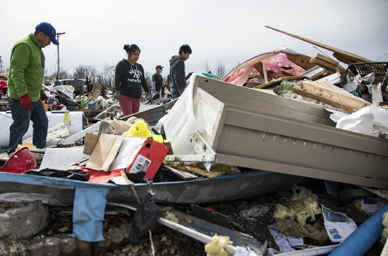 Staff photo by Troy Stolt / Manuel Tomas, left, Maria Tomas, center, and Luciano Tomas, right, sort through what remains of their home after it was destroyed by a tornado early Tuesday in Cookeville, Tenn. on Wednesday, March 4, 2020. A tornado destroyed 140 buildings in Putnam County early Tuesday, killing at least 18 people, and leaving many without homes.