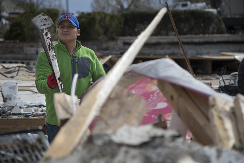 Staff photo by Troy Stolt / Manuel Tomas holds up a piece of debris where his home used to be on Wednesday, March 4, 2020 in Cookeville, Tenn. A tornado destroyed 140 buildings in Putnam County early Tuesday, killing at least 18 people, and leaving many without homes.