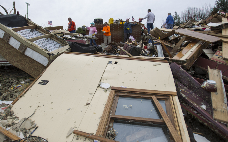 Staff photo by Troy Stolt / Volunteers form a line to sort through debris at the home of the late Jessica Clark, in Cookeville, Tenn on Wednesday, March 4, 2020. A tornado destroyed 140 buildings in Putnam County, killing at least 18 people early Tuesday, Clark was one of those who was killed.
