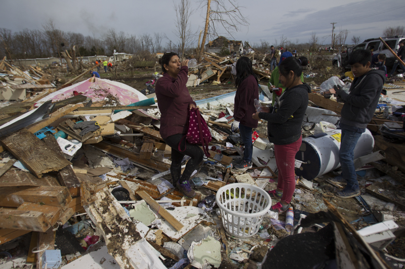 Staff photo by Troy Stolt / The Tomas Family takes a break from sorting through what remains of their home in Cookeville, Tenn on Wednesday, March 4, 2020. A tornado destroyed 140 buildings in Putnam County early Tuesday, killing at least 18 people, and leaving many without homes.