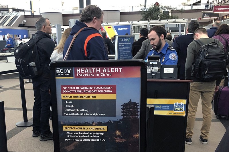 FILE - In this Monday, March 2, 2020 file photo, a health alert for people traveling to China is shown at a TSA security checkpoint at the Denver International Airport in Denver. A steep drop in business travel could be a gut punch to a tourism industry already reeling from the coronavirus outbreak, as big companies like Amazon try to keep employees healthy by banning trips. (AP Photo/Charles Rex Arbogast, File)


