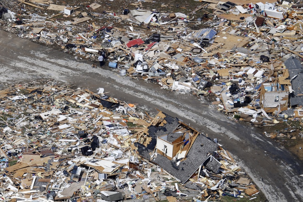 A road separates properties filled with debris Tuesday, March 3, 2020, near Lebanon, Tenn. Tornadoes ripped across Tennessee early Tuesday, shredding more than 140 buildings and burying people in piles of rubble and wrecked basements. (AP Photo/Mark Humphrey)