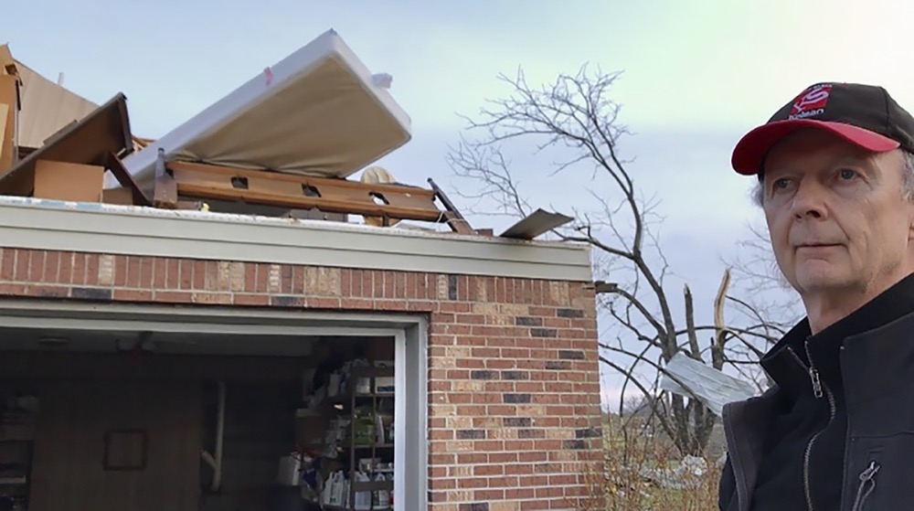 In this Tuesday, March 3, 2020 photo, Billy Dyer of Baxter, Tenn., stands beside his home damaged by an early morning tornado, in Baxter, Tenn. The walls on the upper floor around his bedroom are gone. Cell phone emergency alerts gave him and his wife enough time to get to the basement. Tornadoes that struck Tennessee early Tuesday killed at least 24 with an unspecified number of people still missing. (AP Photo/Teresa M. Walker)