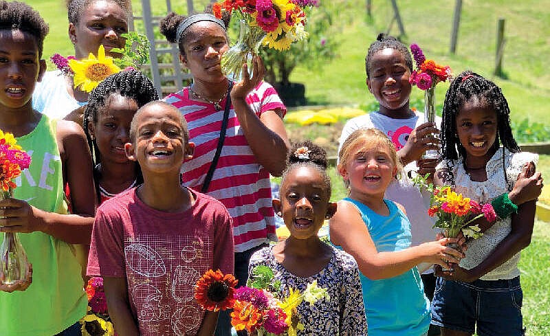 Kids of Growth program participants Michael Dews; Chayna Chapman; Africa Davis; A'Ryah, Michael and Mariah Dews; Ava Porter; and Adrienne and Johnniah Dews gather flowers from their garden on Chattanooga's Westside. / Contributed by Amy Farlett