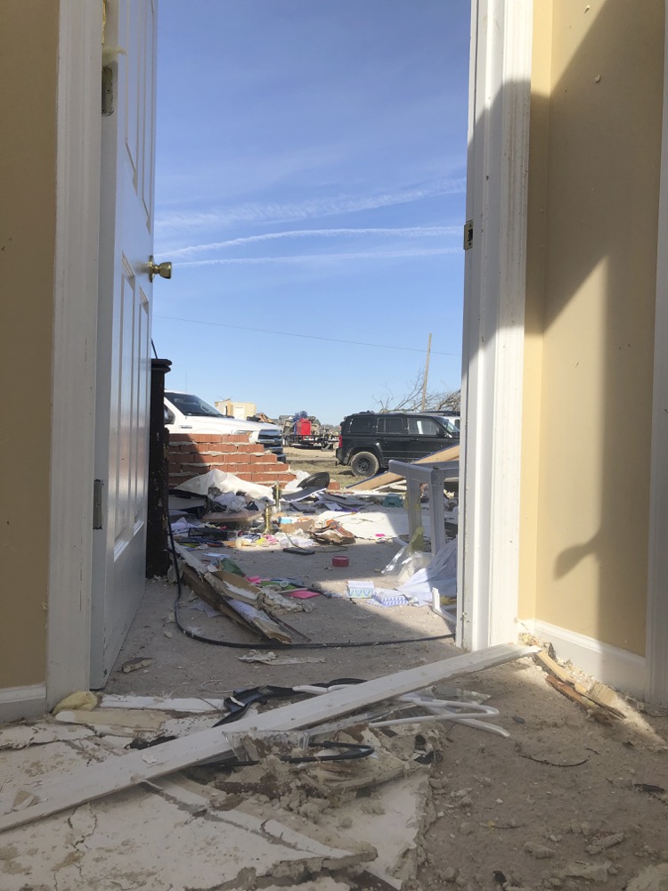 A view from the front door of Jose Cojom's tornado-wrecked home in Putnam County, Tennessee on Wednesday, March 4. After the pre-dawn tornado on Tuesday, volunteers came on Wednesday to cut apart damaged tress and sort through debris. (AP Photo/Travis Loller)