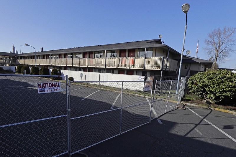 A fence limits access to a back parking area of an Econo Lodge motel in Kent, Wash., Wednesday, March 4, 2020. King County Executive Dow Constantine said Wednesday that the county had purchased the 85-bed motel — which is currently open and operating — south of Seattle to house patients for recovery and isolation due to the COVID-19 coronavirus. (AP Photo/Ted S. Warren)